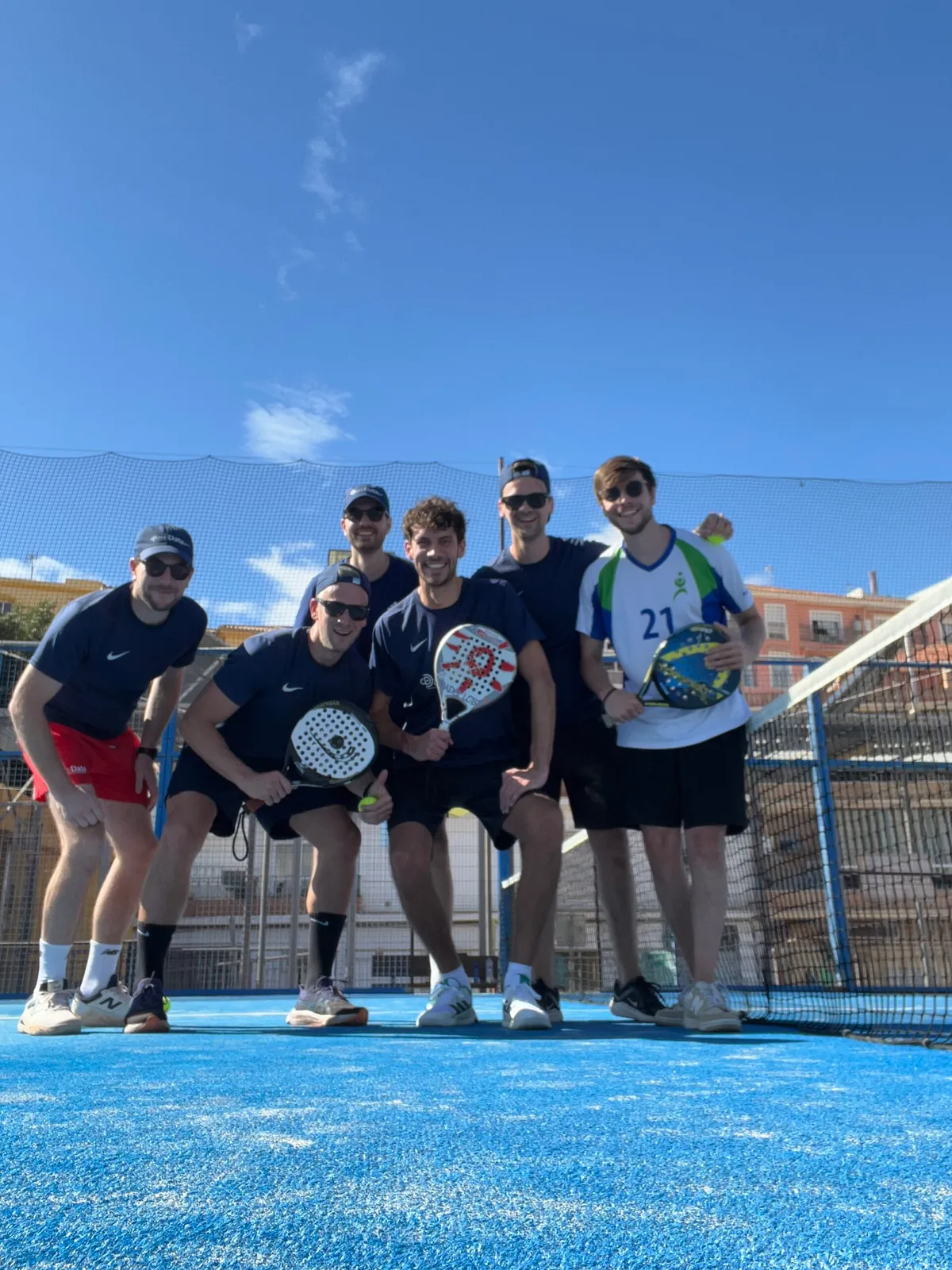 Teamfoto op een padelbaan na een wedstrijd