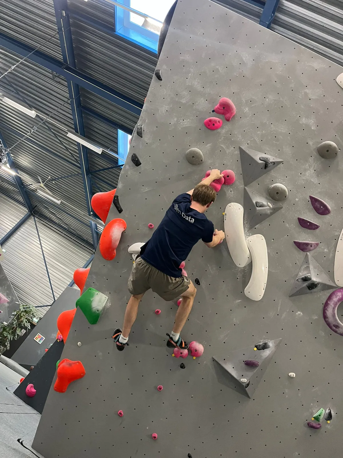 Collega klimt een boulderwand tijdens een teamuitje Collega klimt een boulderwand tijdens een teamuitje