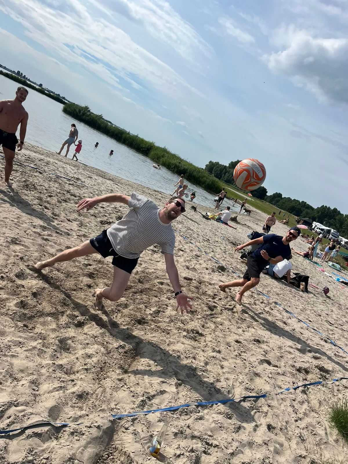 Collega’s spelen een balspel op het strand tijdens een teamuitje