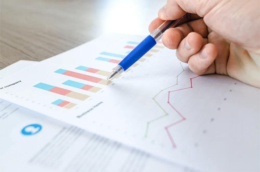 Hand wijst naar grafieken en datavisualisaties op een rapport